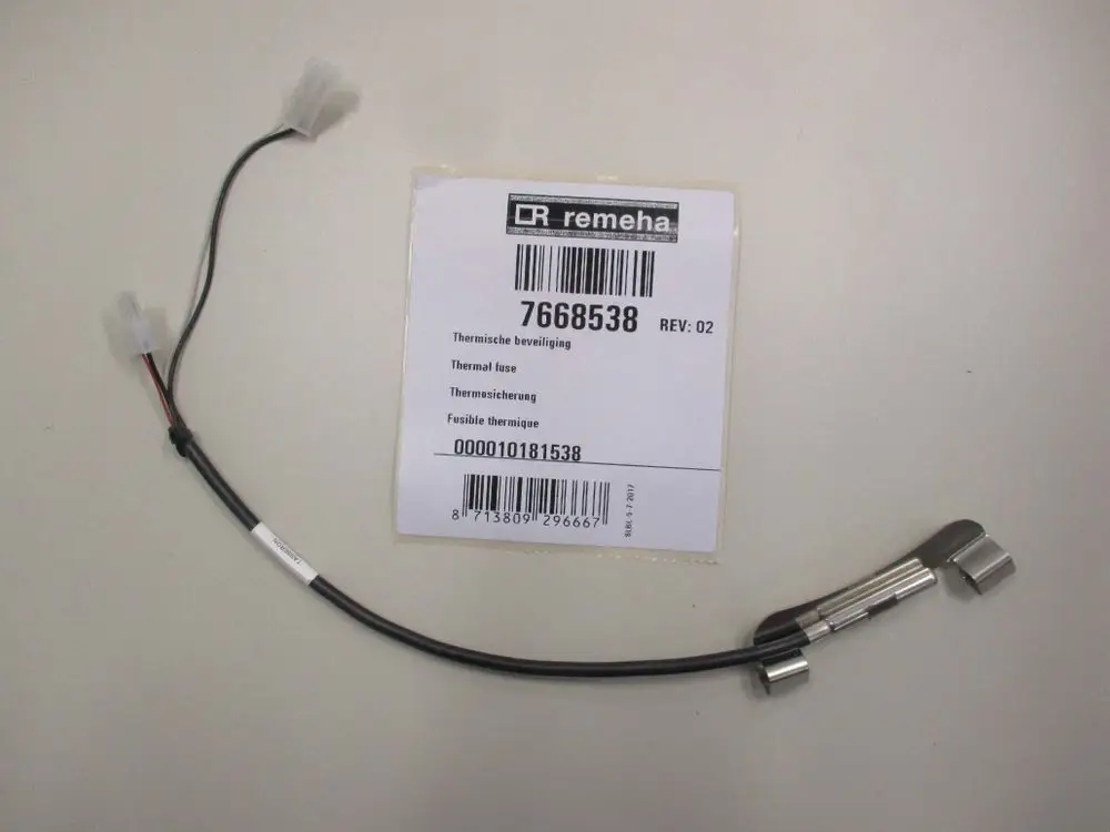 Thermosicherung von Remeha mit zwei Anschlüssen. Kabel mit Stecker und metallischem Gehäuse. Produktinformationen auf einem beigelegten Etikett.